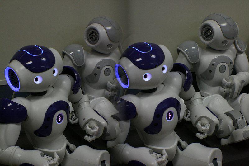 Several robots with glowing blue eyes sitting together