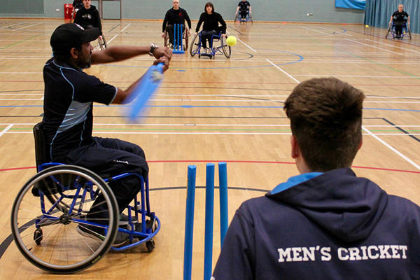 a group of students are playing wheelchair cricket at the ӶƵ